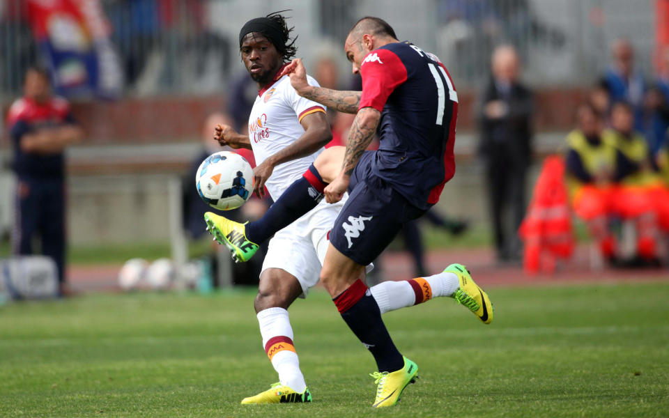 Cagliari's Francesco Pisano kicks the ball past Roma's Gervinho during a Serie A soccer match between Cagliari and Roma in Cagliari, Italy, Sunday, April 6, 2014. (AP Photo/Daniela Santoni)