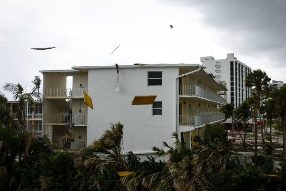 Debris flies off a roof ahead of Hurricane Idalia in Fort Myers on Tuesday.