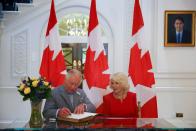 <p>He signs a guest book at Canada House in London. </p>