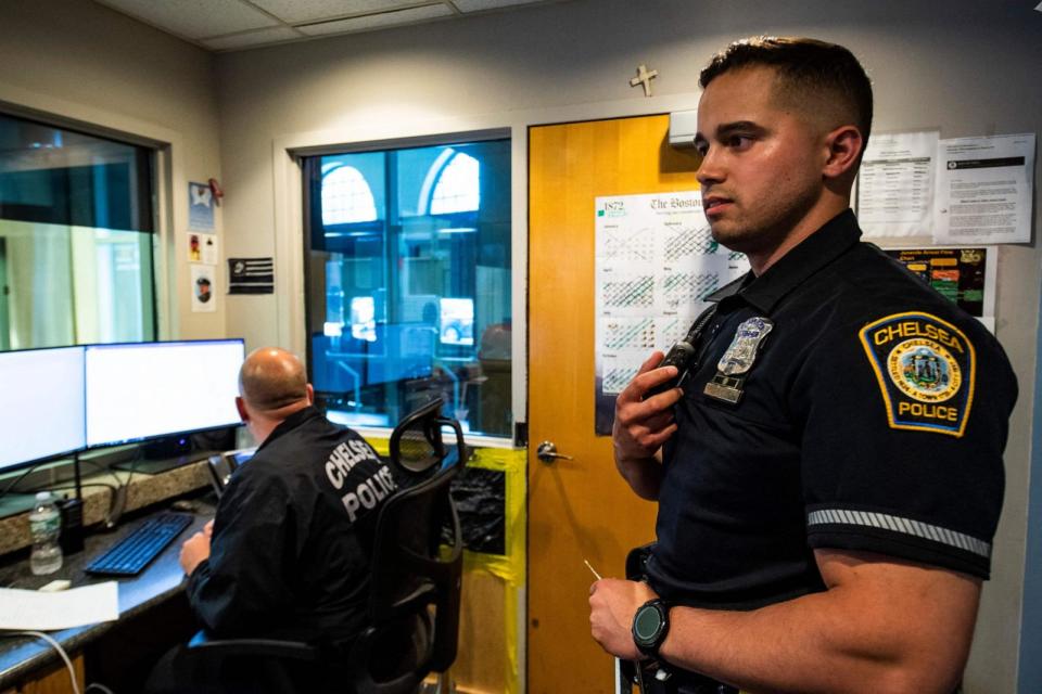 PHOTO: Officer Jose Rodriguez, 32 (R), answers a call on his radio while inside the dispatch room at the police station in Chelsea, Mass., May 13, 2022. (Joseph Prezioso/AFP via Getty Images)