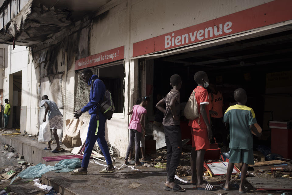 A man walks out a destroyed supermarket in Dakar, Senegal, Saturday, June 3, 2023. Senegal's government says at least nine people have been killed in violent clashes between police and supporters of opposition leader Ousmane Sonko, with authorities issuing a blanket ban on the use of several social media platforms in the aftermath of the violence. (AP Photo/Leo Correa)