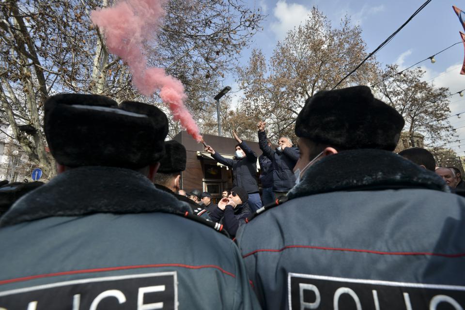 Police block opposition demonstrators letting off flares, as they guard Armenian Prime Minister Nikol Pashinyan's supporters rally in the central in Yerevan, Armenia, Thursday, Feb. 25, 2021. Armenia's prime minister accused top military officers on Thursday of attempting a coup after they demanded he step down, adding fuel to months long protests calling for his resignation following the nation's defeat in a conflict with Azerbaijan over the Nagorno-Karabakh region. (Karo Sahakyan/PAN Photo via AP)