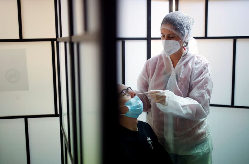 A medical worker administers a nasal swab to a patient at a coronavirus disease (COVID-19) testing centre in Les Sorinieres