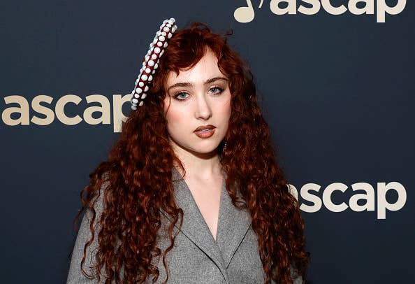 A woman with long curly hair wearing a stylish gray blazer and a beaded headband at an ASCAP event