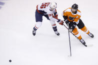 Washington Capitals center Nic Dowd (26) and Philadelphia Flyers center Sean Couturier (14) vie for the puck during the second period of an NHL hockey playoff game Thursday, Aug. 6, 2020, in Toronto. (Cole Burston/The Canadian Press via AP)