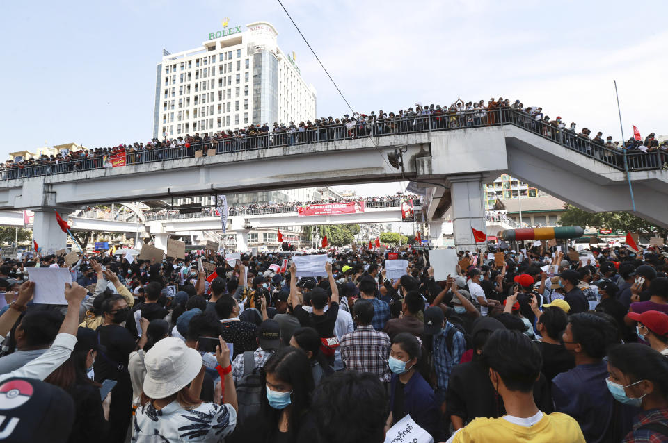 Protesters gather at an intersection while others watch from an elevated walkway in Yangon, Myanmar on Monday, Feb. 8, 2021. Tension in the confrontations between the authorities and demonstrators against last week's coup in Myanmar boiled over Monday, as police fired a water cannon at peaceful protesters in the capital Naypyitaw. (AP Photo)