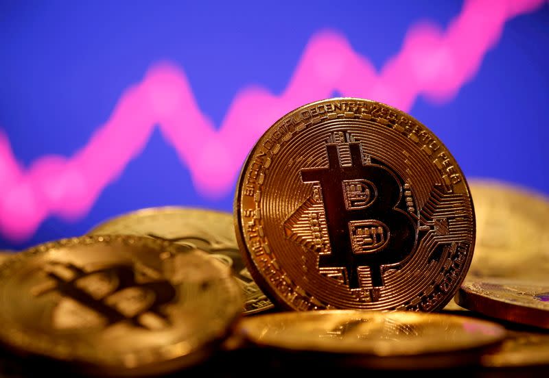 FILE PHOTO: A representation of virtual currency Bitcoin is seen in front of a stock graph in this illustration taken