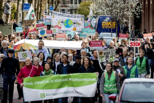 Dozens of activists march toward Shell's base in The Hague, where they will deliver a legal summons with a court date set for April 17, 2019