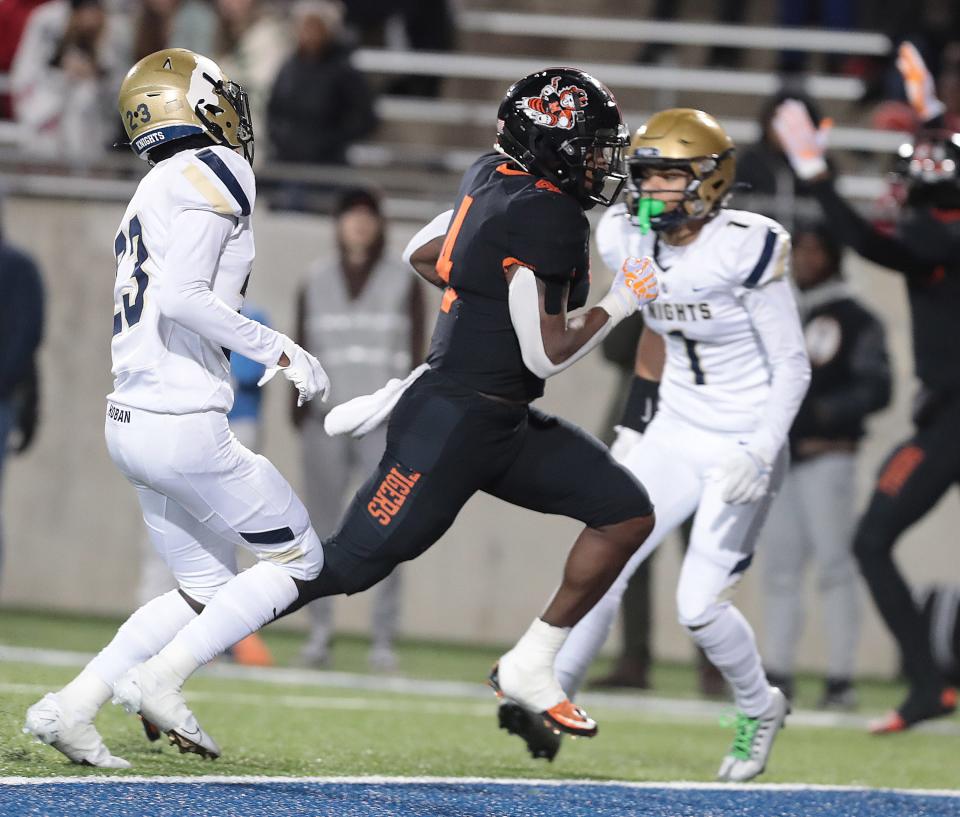 Massillon running back Willtrell Hartson splits the defense of Hoban's Xavier Williams left, and Payton Cook in the first half during this OHSAA Division II state semifinal game Friday, Nov. 25, 2022 at the University of Akron.
