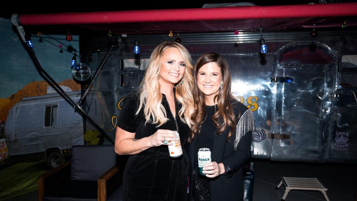 miranda lambert and katie beal brown standing next to each other holding ranch water