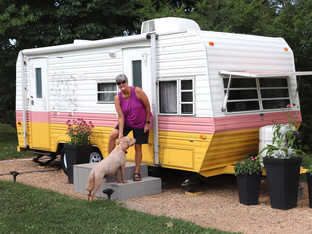 Adrienne Smith with one of her dogs outside her Dolly Parton-themed RV.