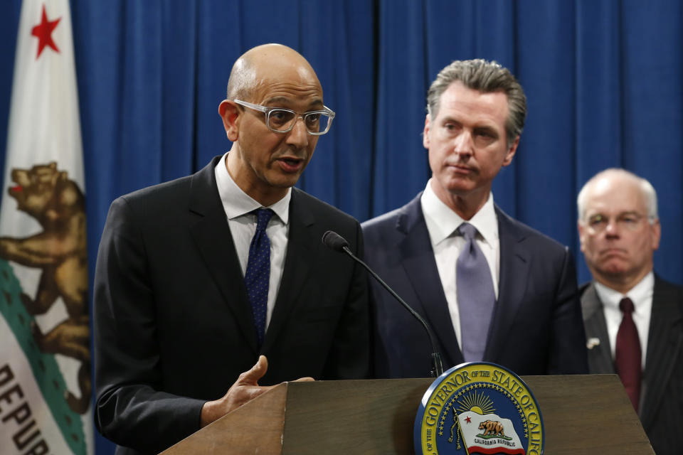 FILE - In this March 12, 2020, file photo, Dr. Mark Ghaly, secretary of the California Health and Human Services, discusses the coronavirus as Gov. Gavin Newsom, center, listens at a news conference in Sacramento, Calif. California's health department on Monday, Jan. 25, 2021, released to the public previously secret data points used to determine future hospital intensive care unit capacity, the key metric for lifting the state's coronavirus stay-at-home order. (AP Photo/Rich Pedroncelli, File)