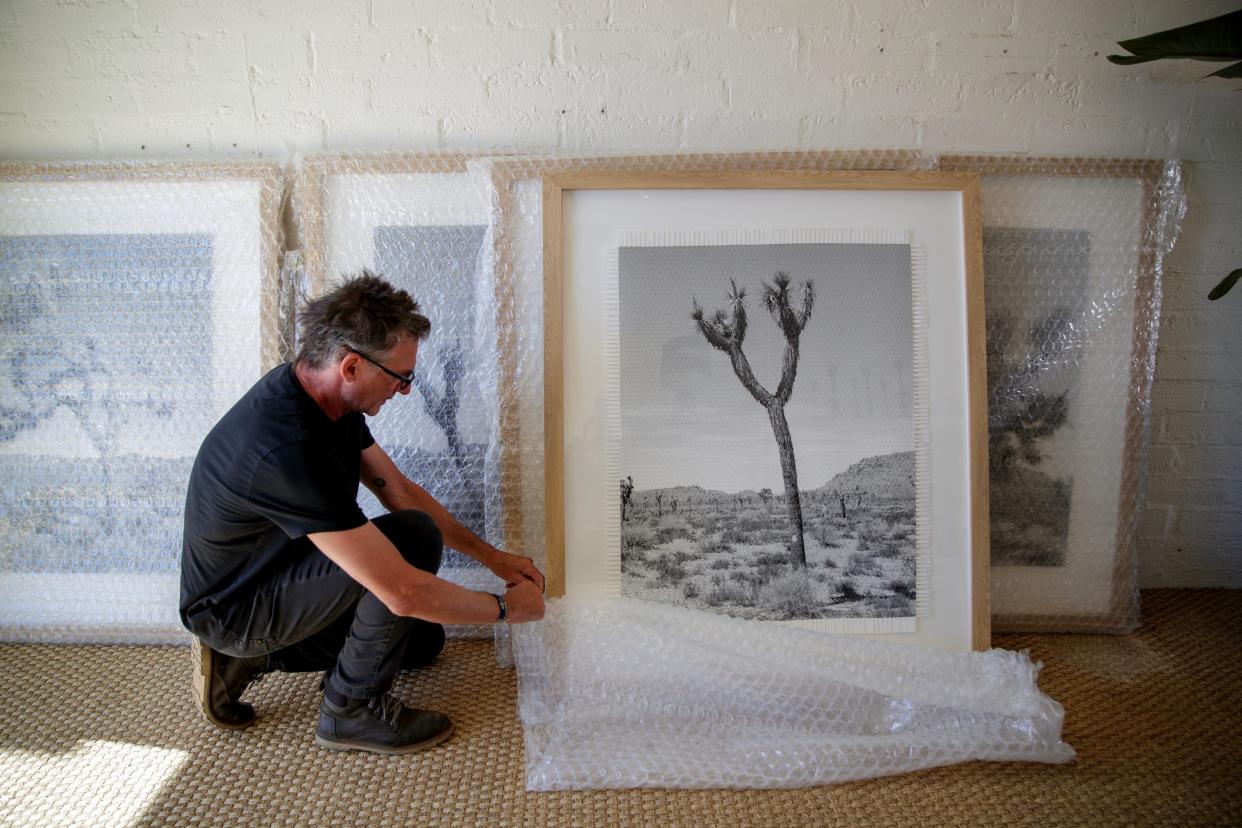 Argentine artist Marcelo Bengoechea prepares his “Karma Tree” artwork series for sale and on exhibit inside Super Simple in Palm Springs, Calif., on Wednesday, Feb. 15, 2023. Bengoechea’s late brother, Fernando Bengoechea, pioneered the woven photography technique of weaving two identical prints to create one image. Marcelo has made it his mission to keep his brother’s art alive. 