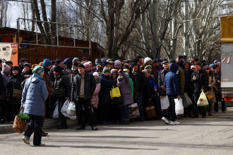 People queue for a meal distribution in Kherson