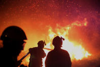 <p>Firefighters spray water as they try to douse a fire near the village of Biguglia, Corsica island, France, July 25, 2017. Hundreds of firefighters are battling blazes fanned by high winds in more than a dozen zones in the Riviera region of southern France. (Raphael Poletti/AP) </p>