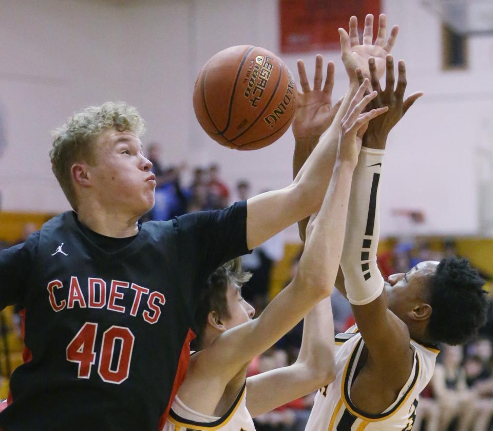 Hilton's Ben Sneddon pulls down a rebound away from Athena's Brandon Krout and Javon Barfield.