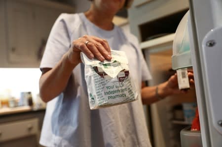 Georgina takes a pharmacy bag containing insulin medical supplies from the fridge in London