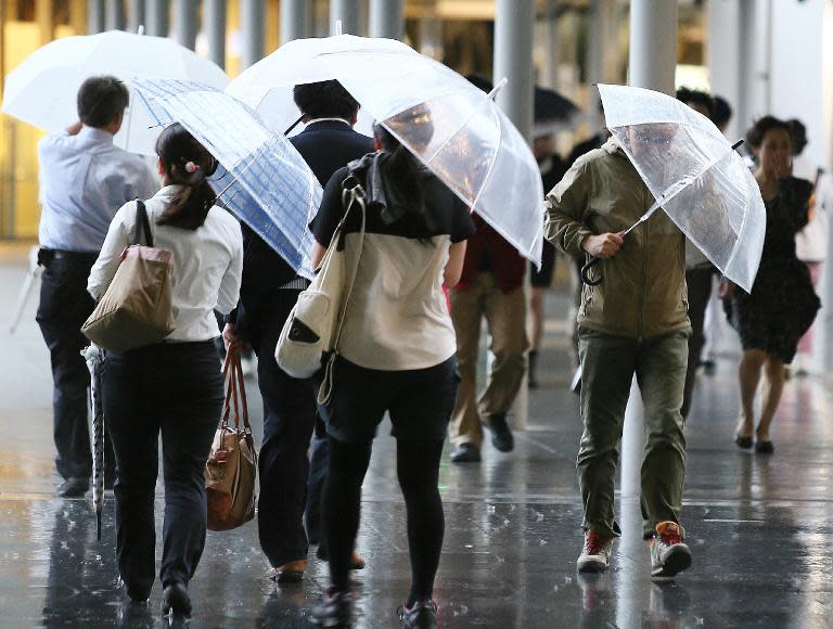 People shelter from heavy winds and rain in Osaka, western Japan, on October 13, 2014