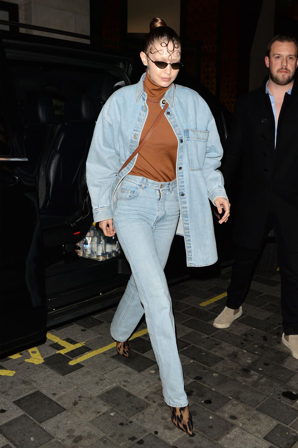 <p>In a light-wash denim jacket, brown turtleneck, matching jeans, and leopard print boots. </p>