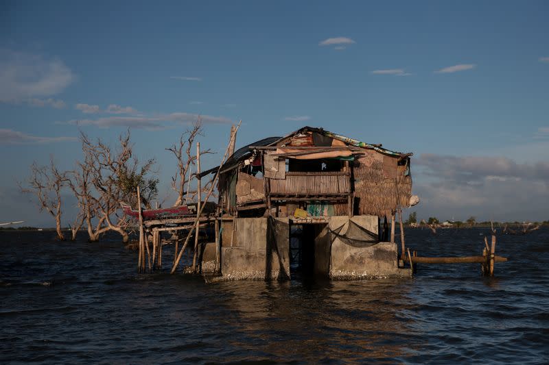 The Wider Image: Rising seas threaten early end for sinking village in Philippines