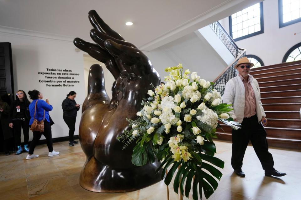 A floral arrangement stands next to the sculpture by Colombian artist Fernando Botero, titled The Hand, at the Botero Museum in Bogota, Colombia on Sept. 15, 2023.