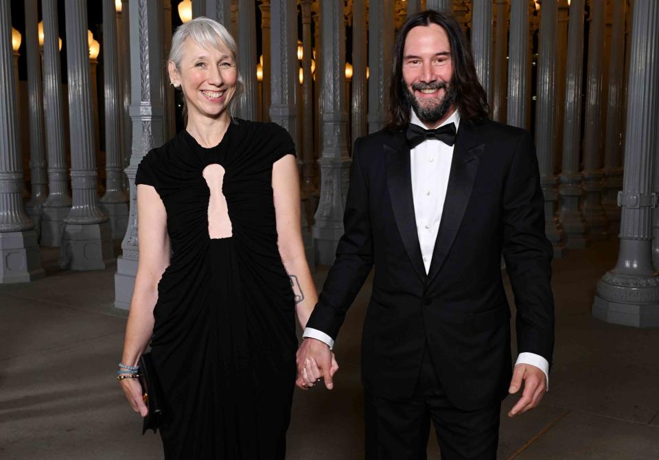 <p>Michael Kovac/Getty Images for LACMA</p> Alexandra Grant and Keanu Reeves holding hands at the 2023 LACMA Art + Film Gala.