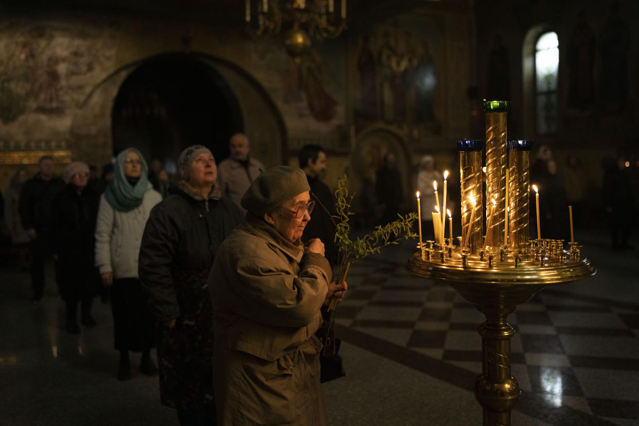 A woman makes the sign of the cross during an Orthodox Palm Sunday service.