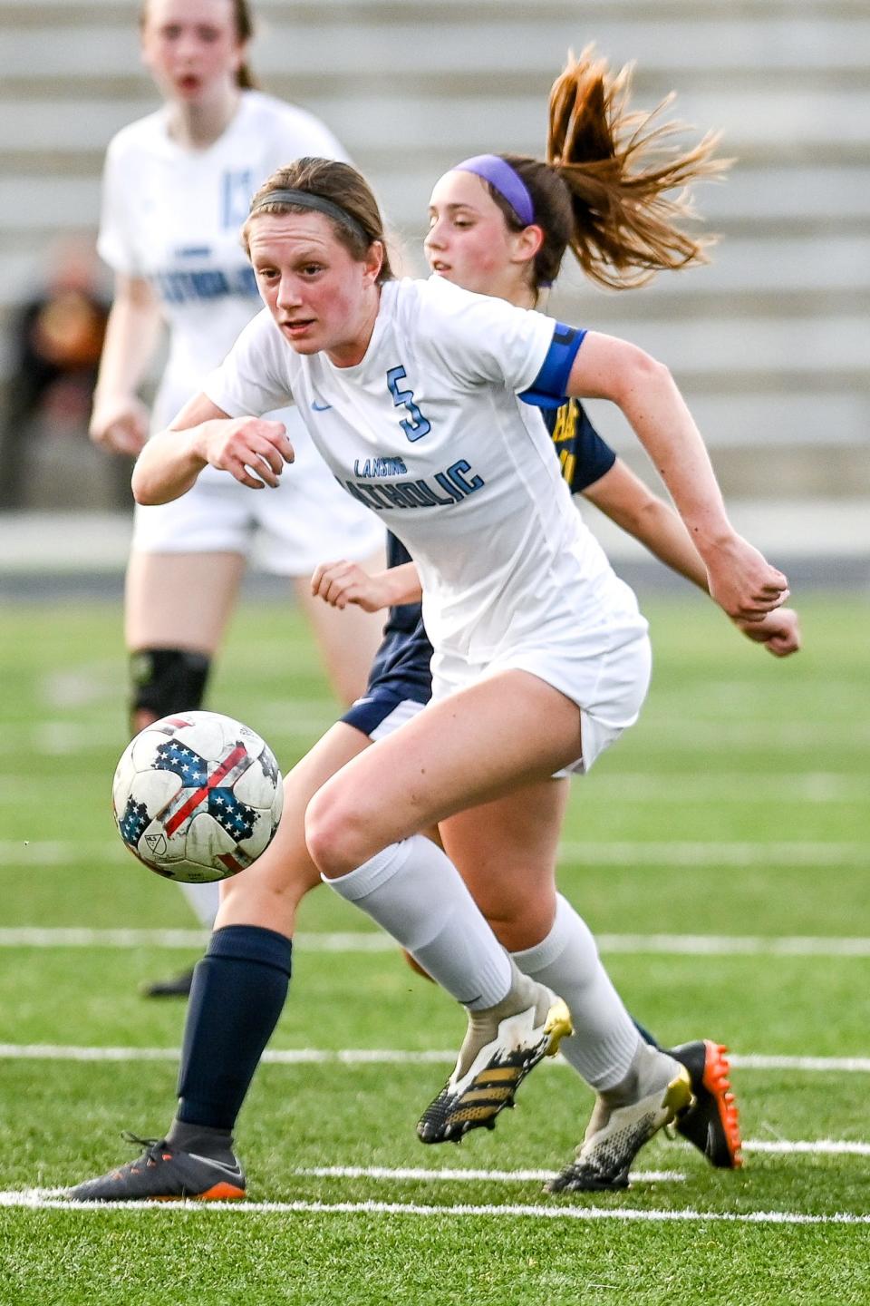 Lansing Catholic's Maddie O'Farrell moves the ball against Haslett during the first half on Tuesday, May 18, 2021, at Haslett High School.