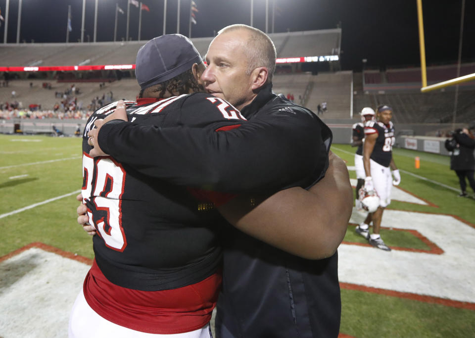 North Carolina State coach Dave Doeren hugs defensive tackle Alim McNeill (29) after the team's 23-13 victory over Georgia Tech in an NCAA college football game in Raleigh, N.C., Saturday, Dec. 5, 2020. (Ethan Hyman/The News & Observer via AP, Pool)