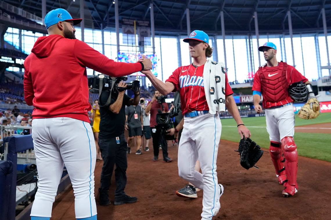 Miami Marlins starting pitcher Max Meyer, center, shakes hands with pitcher Pablo Lopez, left, as he walks to the dugout with catcher Jacob Stallings, right, for his pitching debut in a baseball game against the Philadelphia Phillies, Saturday, July 16, 2022, in Miami.