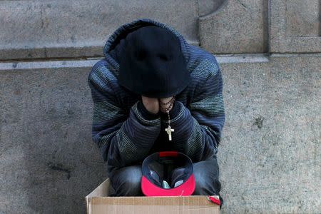 A homeless man sits along a sidewalk on East 42nd Street in the Manhattan borough of New York City, January 4, 2016. REUTERS/Mike Segar