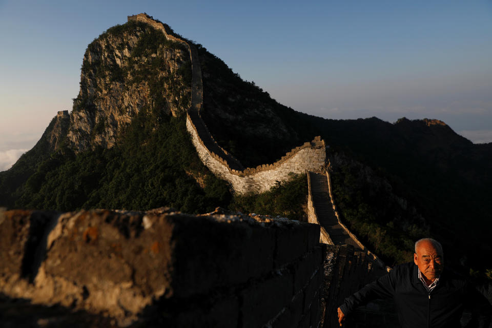 <p>Cheng Yongmao, the engineer in charge of the reconstruction project on the Jiankou section of the Great Wall, looks as the sun rises over the wall, located in Huairou District, north of Beijing, China, June 7, 2017. (Photo: Damir Sagolj/Reuters) </p>