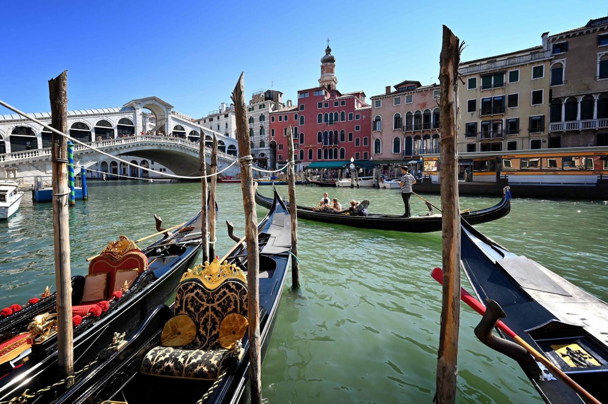People take a gondola ride by the Rialto Bridge on the Grand Canal in Venice on September 9, 2020, on the eighth day of the 77th Venice Film Festival, during the COVID-19 infection, caused by the novel coronavirus.
