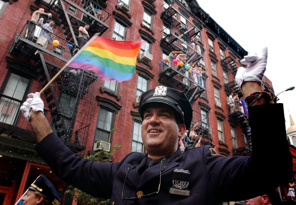 <p>An iconic New York City photo, police officers march down waving rainbow flags during a Pride parade. <br></p>