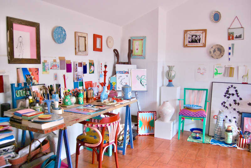 Art supplies and easels in white studio area.