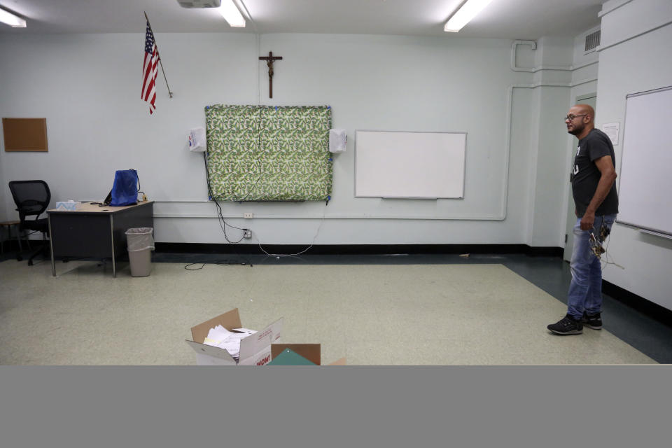 Facilities manager Charles Fabian stands in an empty classroom at Queen of the Rosary Catholic Academy in Brooklyn borough of New York, Thursday, Aug. 6, 2020. In July the Archdiocese of Brooklyn and Queens announced that six Catholic schools in the two boroughs will close permanently at the end of August due to debt and low enrollment aggravated by the coronavirus pandemic. (AP Photo/Jessie Wardarski)