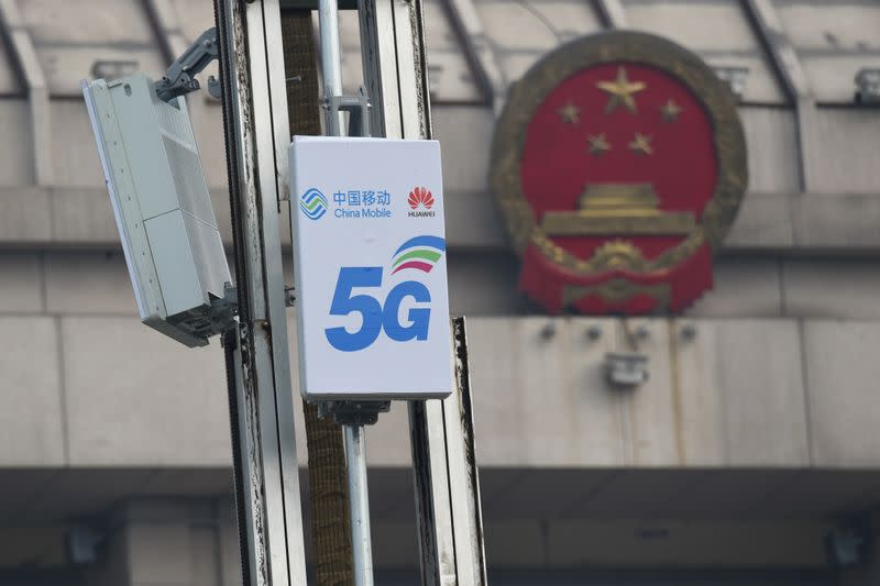 5G active antenna units with logos of China Mobile and Huawei are seen in front of a National People's Congress (NPC) conference center in Luoyang, Henan