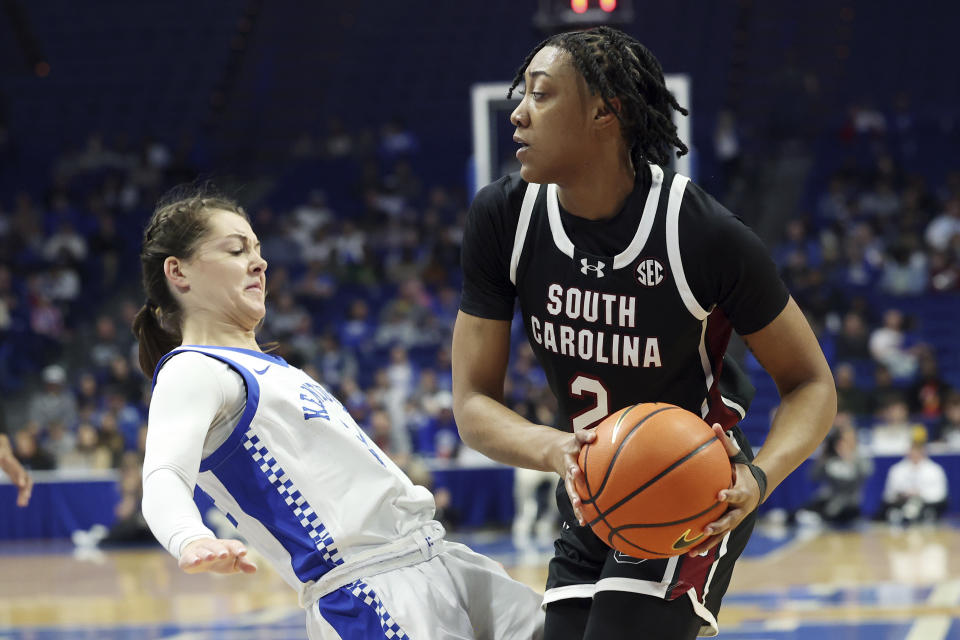 South Carolina's Ashlyn Watkins, right, collides with Kentucky's Emma King (34) during the first half of an NCAA college basketball game Sunday, Feb. 25, 2024, in Lexington, Ky. Watkins was called for a charge. (AP Photo/James Crisp)