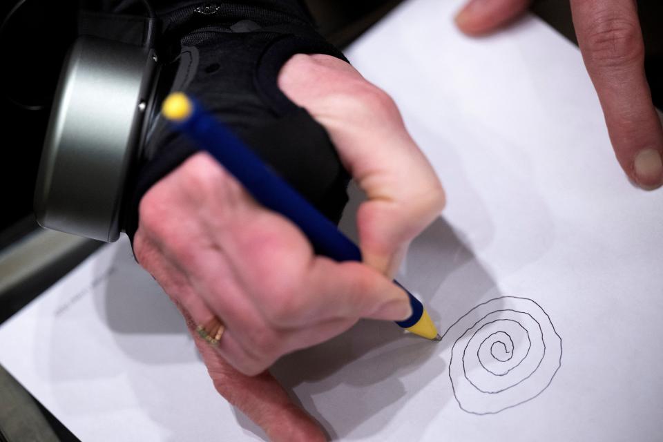 Roberta Wilson-Garrett, of Blind River, Ontario, who has Parkinson's disease, draws a spiral while using her GyroGlove, made by GyroGear, which uses a gyroscope to help stabilize tremors at the Mandalay Bay resort before this week's Consumer Electronics Show (CES) on January 8, 2024 in Las Vegas, Nevada.