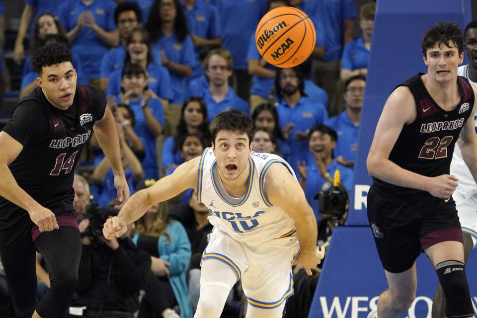 UCLA guard Lazar Stefanovic, center, chases a loose ball along with Lafayette forward Kyle Jenkins, left, and forward Chris Rubayo during the second half of an NCAA college basketball game Friday, Nov. 10, 2023, in Los Angeles. (AP Photo/Mark J. Terrill)