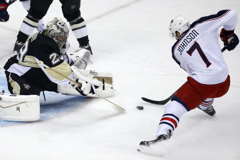 Columbus Blue Jackets' Jack Johnson (7) prepares to put the puck under the pads of Pittsburgh Penguins goalie Marc-Andre Fleury (29) for a goal during the first period of a first-round NHL playoff hockey game in Pittsburgh on Wednesday, April 16, 2014. (AP Photo/Gene J. Puskar)