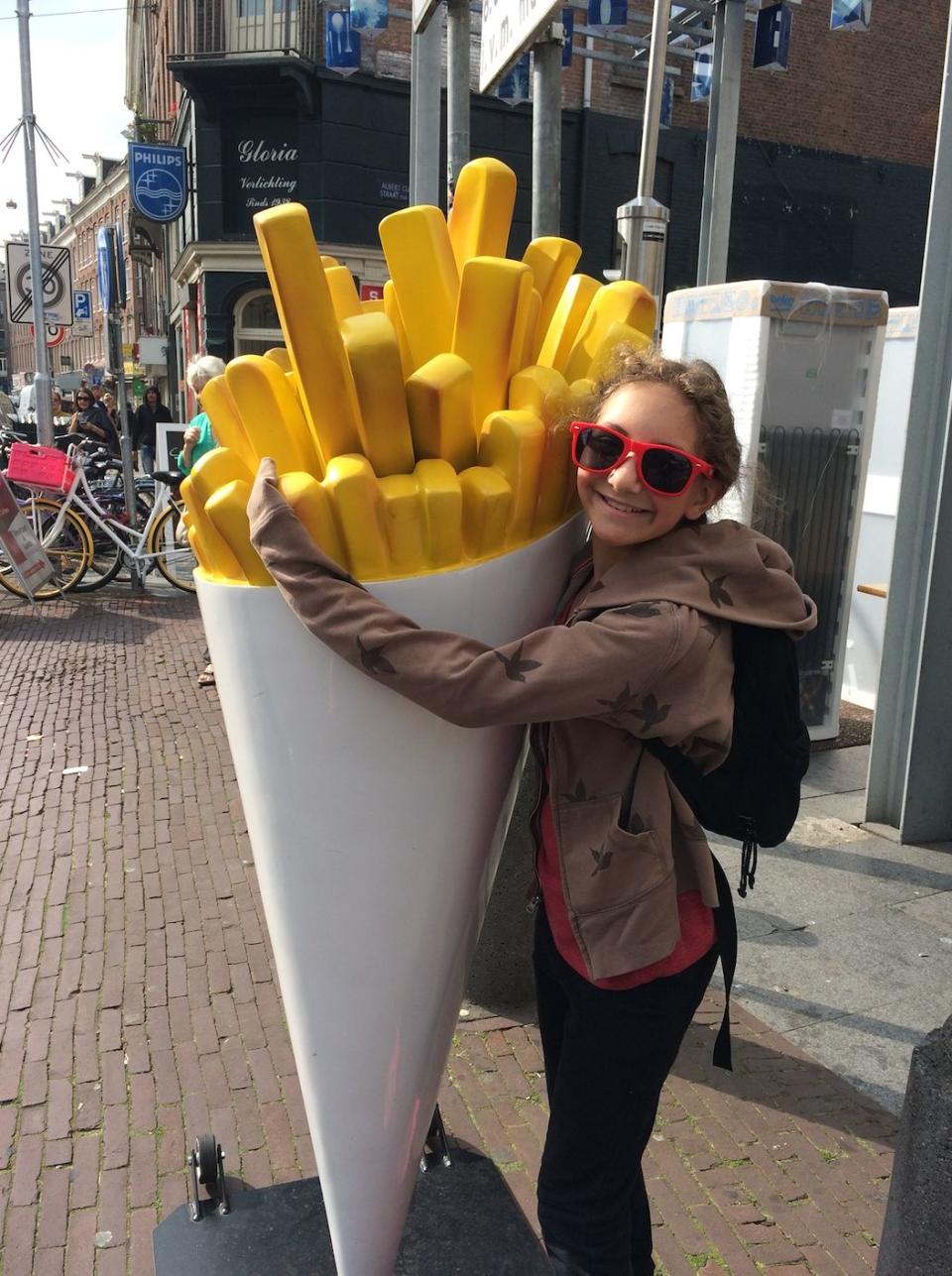 Sammi hugging a statue of french fries during a family trip to Amsterdam. (Photo: Debi Lewis)