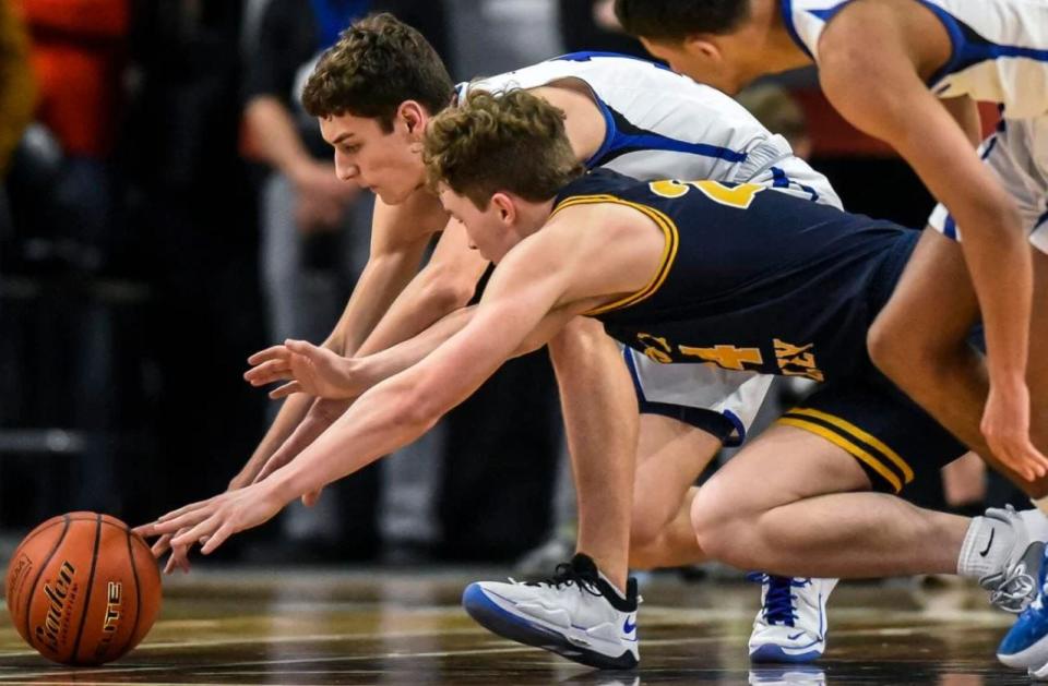 St. Thomas More's Caleb Hollenbeck (10) and Sioux Valley's Oliver Vincent (24) both dive for a loose ball during a game in the semifinals of the Class A state tournament on Friday at Summit Arena.