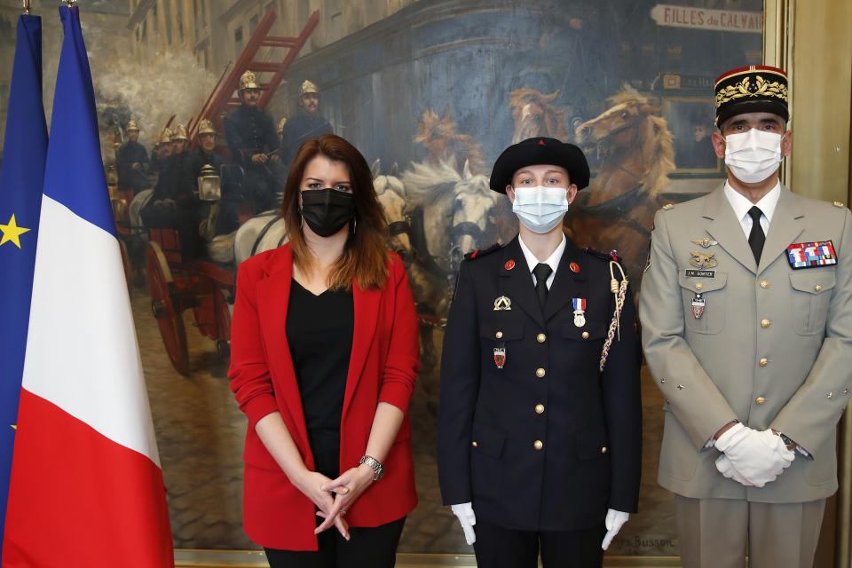 France's minister for citizenship issues, Marlene Schiappa, right, and General commander of the Paris Firefighters Brigade Jean-Marie Gontier, right, pose with a math teacher-volunteer fighter, Marion Dehecq, center, after she received a bronze medal for courage and dedication as she used CPR to save the life of a jogger, during a ceremony at the Paris fire service headquarters in Paris, France, Monday, May 10, 2021. The jogger's wife, Paris-based Associated Press journalist Lori Hinnant, helped identify the anonymous rescuer by putting up thank-you signs in Monceau Park, where her husband Peter Sigal went into cardiac arrest on April 28. (AP Photo/Francois Mori, pool)