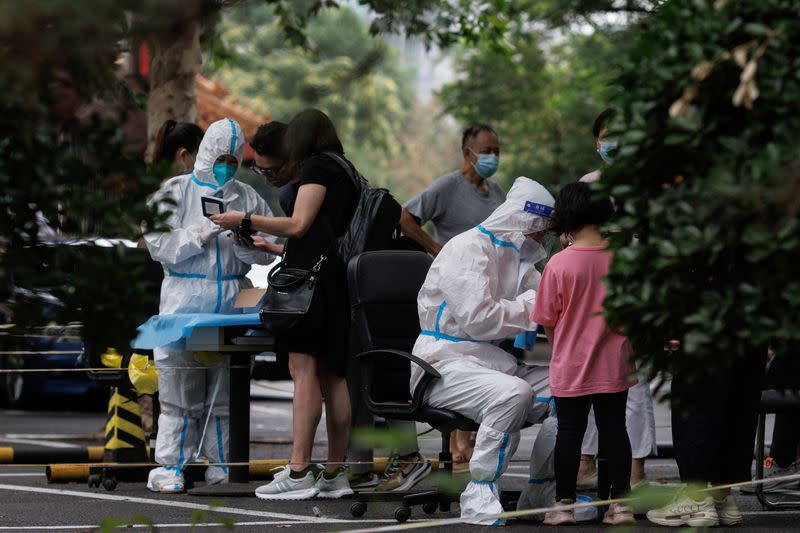 Medical workers register people at a nucleic acid testing station, following a coronavirus disease (COVID-19) outbreak, in Beijing