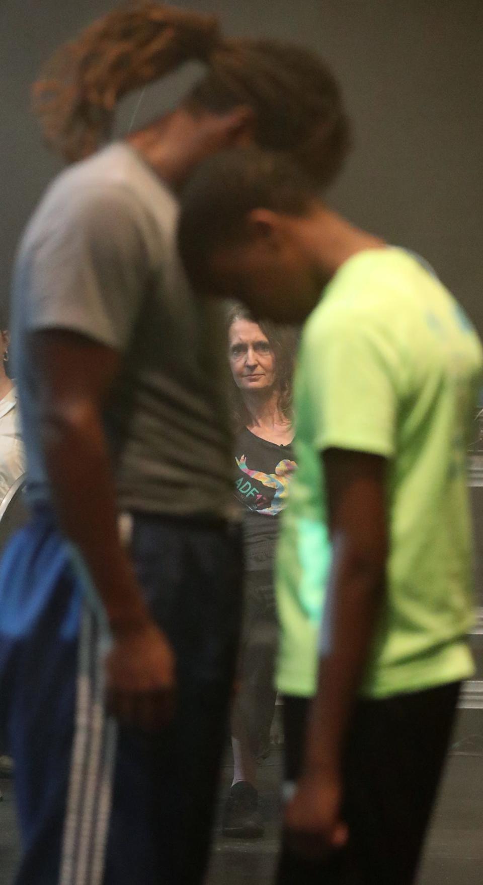 Choreographer/director Kimberly Bartosik watches as Larry White Jr. and James "J2" Shepherd rehearse part of "The Encounter: Akron" in University of Akron's Sandefur Theatre in Guzzetta Hall.