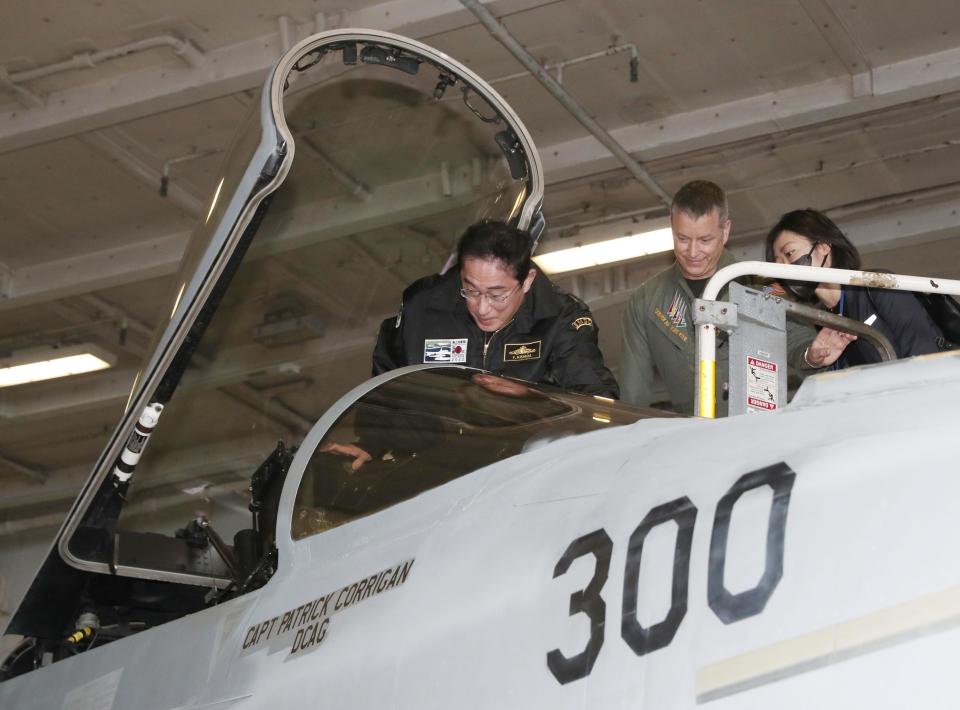 Japanese Prime Minister Fumio Kishida gets in the cockpit of a US fighter jet during his visit to the USS Ronald Reagan, in Sagami Bay, southwest of Tokyo, Sunday, Nov. 6, 2022. Kishida, at an international fleet review Sunday, said his country urgently needs to build up military capabilities as it faces worsening security environment in the East and South China Seas and threats from North Korea’s nuclear and missile advancement and Russia’s war on Ukraine.(Kyodo News via AP)