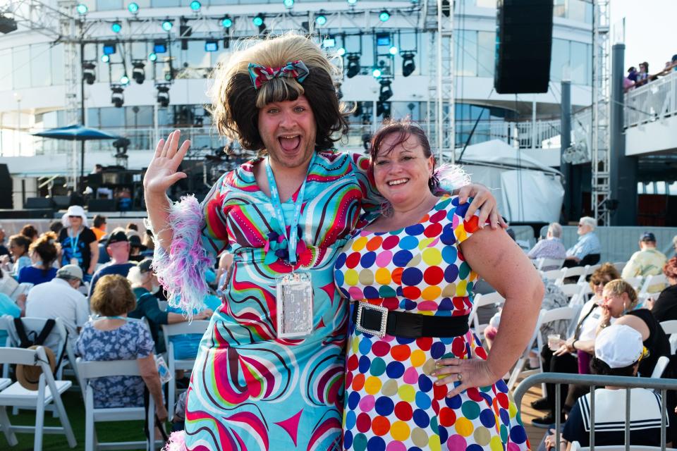 Two people dressed in colorful 1960s outfits.