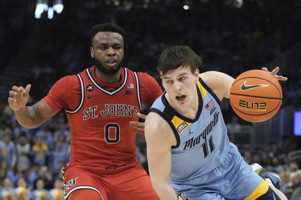 Marquette's Tyler Kolek drives by St. John's's Posh Alexander during the first half of an NCAA college basketball game Saturday, March 4, 2023, in Milwaukee. (AP Photo/Morry Gash)