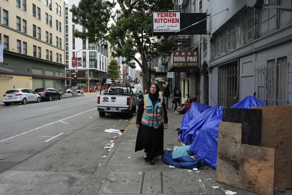 Tatiana Alabsi walks past a small encampment as she roams the Tenderloin neighborhood before children walk to school Wednesday, April 24, 2024, in San Francisco. (AP Photo/Godofredo A. Vásquez)